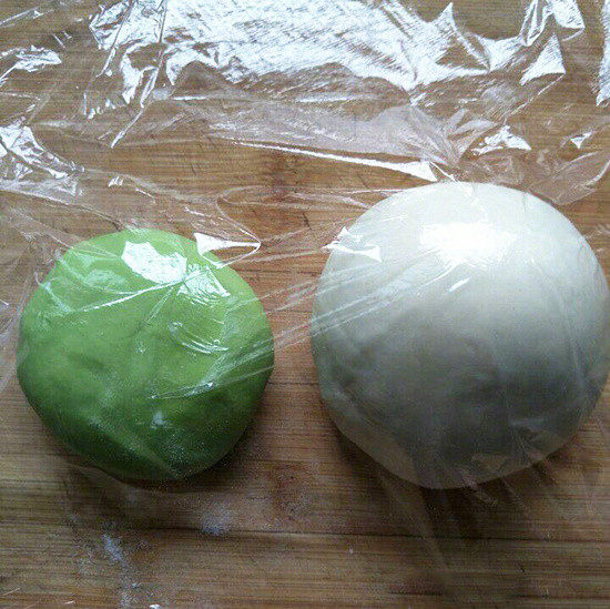 翡翠白菜饺子,雪花粉加上清水和成白面团,和绿面团盖上保鲜膜一起醒15分钟(白面团的体积是绿面团的近2倍);