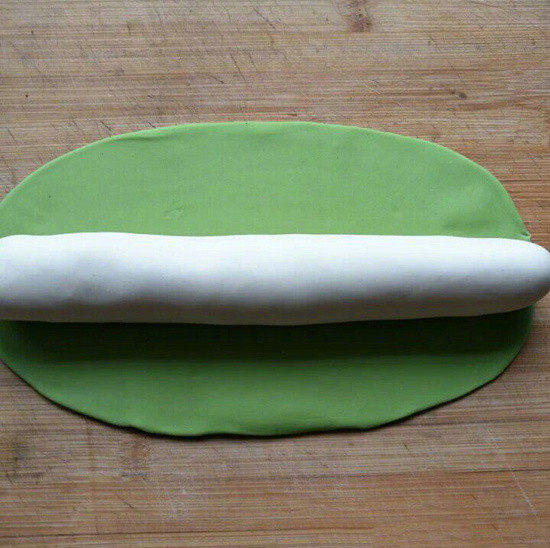 翡翠白菜饺子,将醒发好的白面团再次揉几下后搓成圆柱状,而绿面团则揉几下擀成椭圆状面皮(没有擀面杖可用圆柱体酒瓶或玻璃杯),随后用绿面皮将白面条包起来搓成圆柱体;