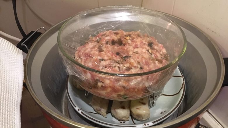菜心蒸肉,封上保鲜膜,进电饭煲,可同时煮米饭或蒸别的食物,只要利用小蒸架。外锅2杯水!