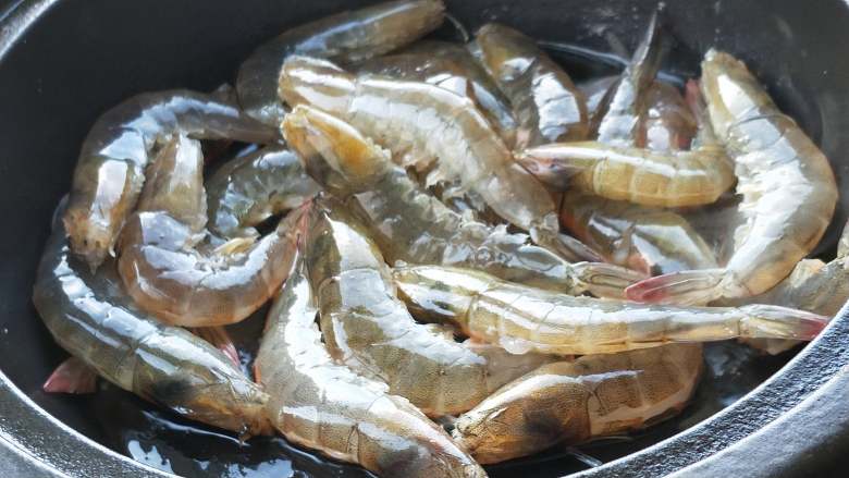 年夜饭之油焖大虾,塔吉锅烧热加油,油烧热放入大虾。