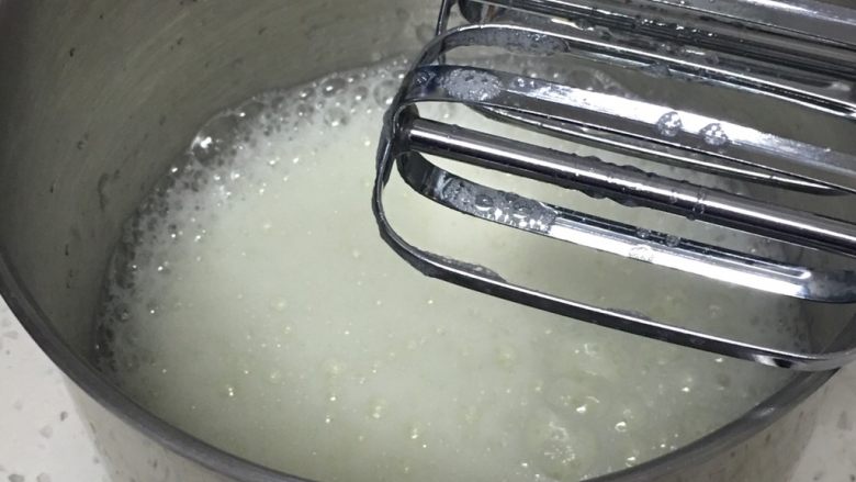 烹调奶油咖啡蛋糕,蛋白出现鱼眼泡后加入30克细砂糖,再用打蛋器高速搅打50圈。