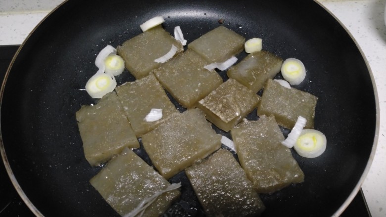 皮扎炒馍,煎至两面定型,放入葱碎。