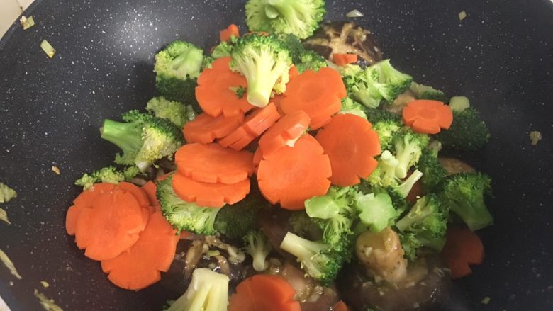 西兰花炒香菇,加入西兰花、胡萝卜翻炒,可加入少许矿泉水