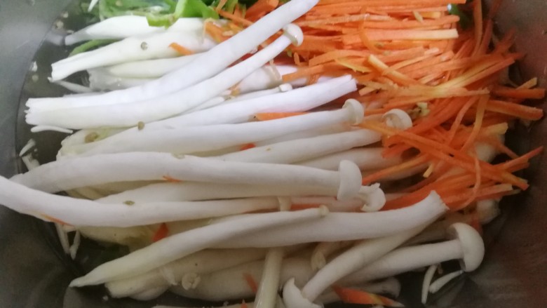 肉炒白玉菇辣椒胡萝卜,将择去根部的白玉菇,辣椒丝,胡萝卜丝放在烧开的水里焯一分钟左右。