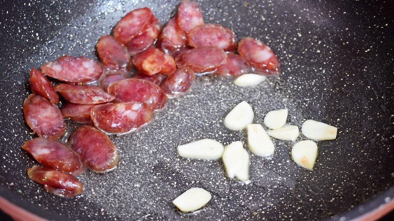 西兰花炒腊肠,把腊肠推到一边,放入蒜片炒出香味