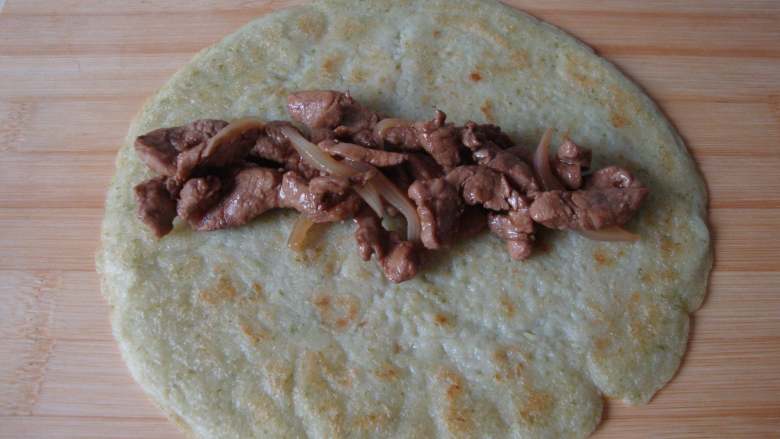 芹菜薄饼卷肉丝,饼中放入炒好的肉丝,卷起来