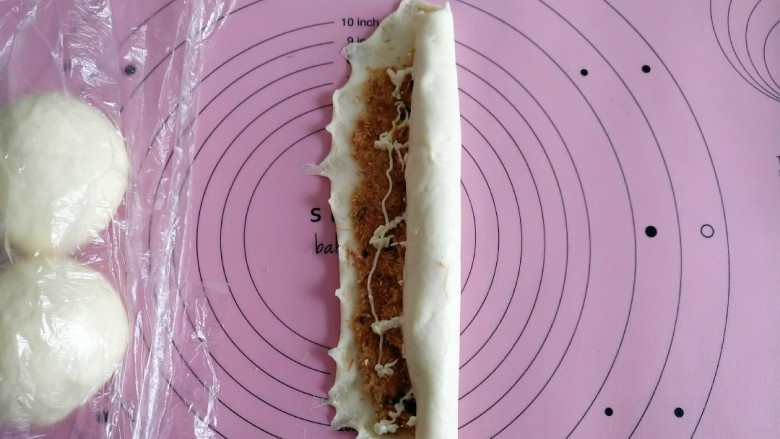 海苔肉松辫子面包,从一端向另一端轻轻卷起 捏紧两端及底部接口 底部朝下。