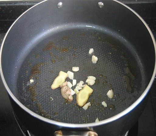 土豆烧肉,锅内热油,加入冰糖小火融化并炒出糖色,加姜片蒜末爆香;
