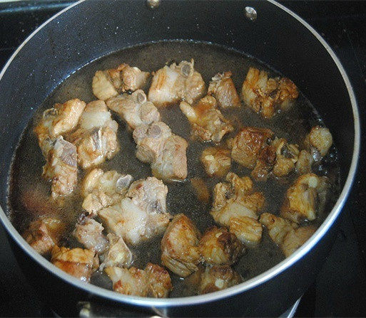 土豆烧肉,倒入没过排骨一半的清水,盖上锅盖焖煮10分钟;
