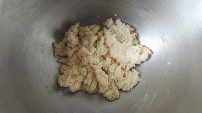 芝麻葱花面包,先用筷子手动将所有材料搅拌成没有干面粉的絮状面团。主要是为了避免启动机器以后,面粉飞溅出来。