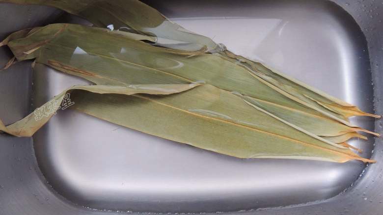 糯米排骨饭,干粽叶清洗干净以后,用清水浸泡2小时左右。