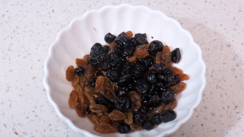 无蛋无油健康版面包【红糖麦香欧包】,将葡萄干和蓝莓干洗干净,清水浸泡至软(或用朗姆酒渍一下做出来的面包风味更好)