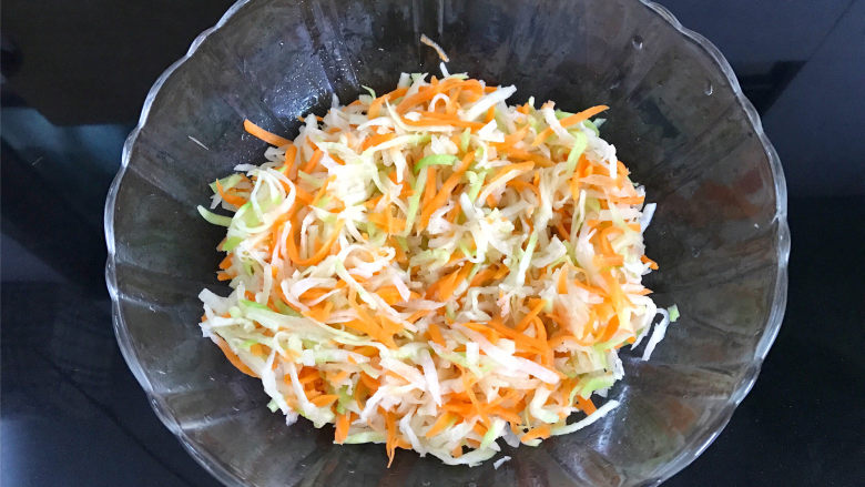萝卜丝饼,加少许盐腌制10分钟后,挤干水份,放入碗中。