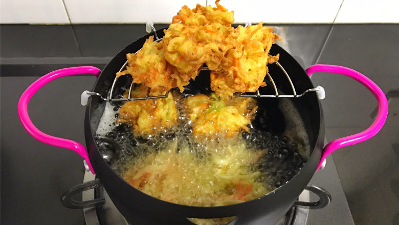 萝卜丝饼,等炸到可以定型后翻面炸另一面,其间要用筷子翻拌一下,防止糊锅,炸至两面呈金黄色后捞出控油。