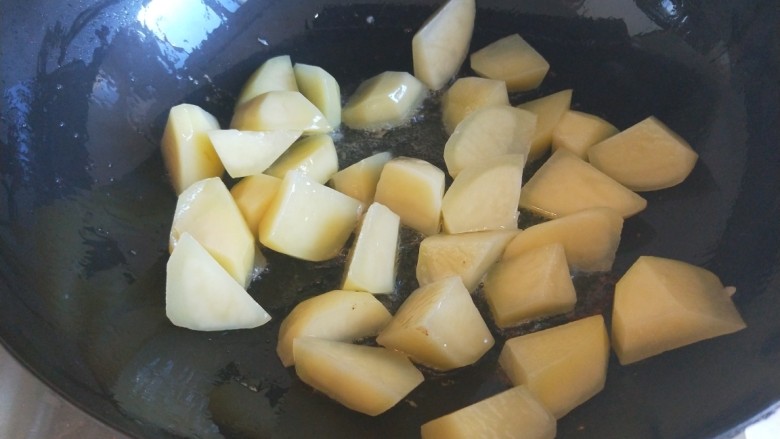 土豆熬金瓜 新文美食,锅中放入适量油倒入土豆。