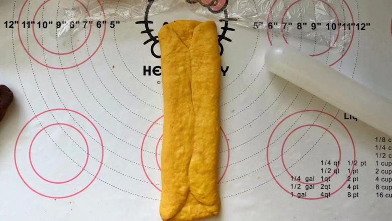 南瓜豆沙排包,11、两边向中间折叠,稍微擀长点。