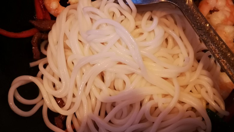牛肉虾仁炒米线,加入米线翻炒,加入生抽和盐调味
