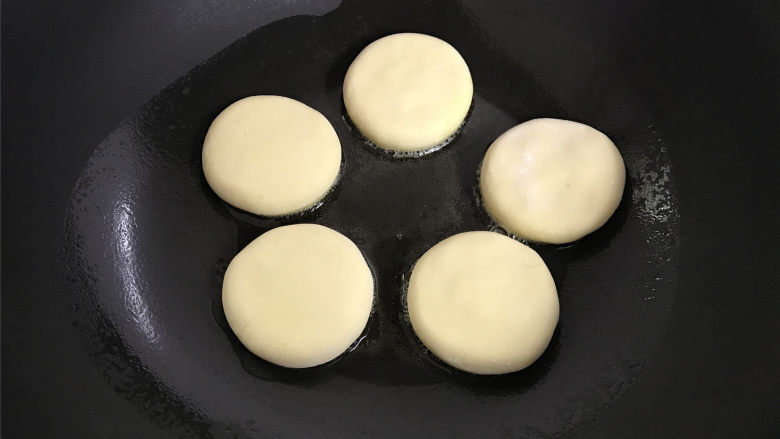 红薯香蕉糯米煎饼,不粘平底锅中倒入适量油,把做好的红薯饼放入锅中。