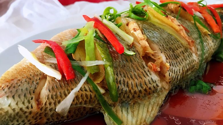 清蒸鲈鱼#年年有余#,铺上葱丝和<a style='color:red;display:inline-block;' href='/shicai/ 72'>柿子椒</a>丝,油烧热,浇上薄层油即可。(油不要浇多了)