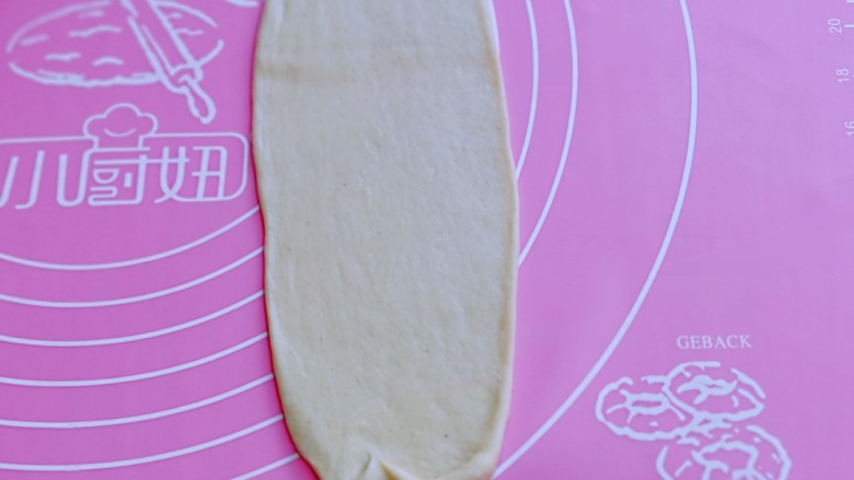 葱香四溢的全麦酸奶面包卷,取一块面团,用擀面杖擀成长舌状。