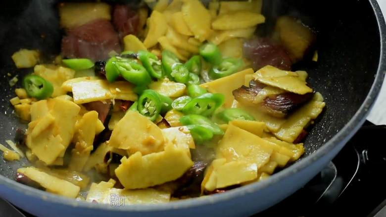 冬笋炒腊肉——沁入心脾,妙不可言的一道菜,加入糖、少许生抽、干辣椒、蒜片、姜丝继续翻炒,最后倒入青椒圈,翻炒均匀即可。