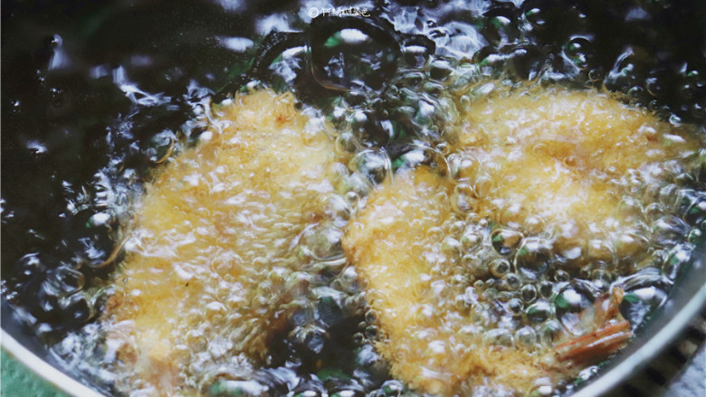 黄金蝴蝶虾,锅里放适量油,烧热后放入大虾炸至金黄色后捞出。