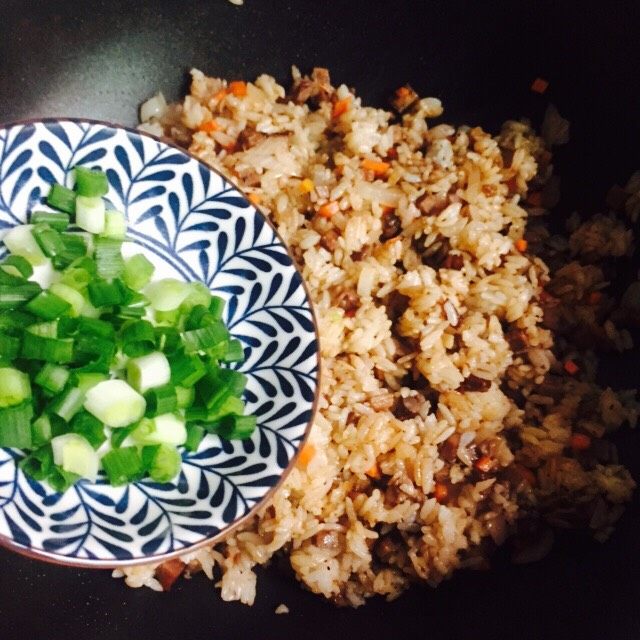 黯然销魂洋葱黑胡椒汁牛肉炒饭,撒葱花翻炒均匀