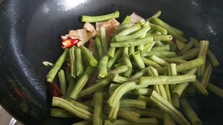 五花肉干煸豆角,倒入豆角干煸。