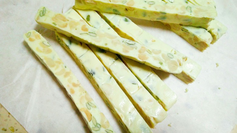 牛轧糖,牛扎糖冷却定型后就可以切了,准备一把锋利的刀,切条