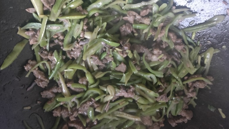 芸豆的新炒法～超级简单下饭的芸豆炒牛肉丝,倒入切好的芸豆丝，翻炒至芸豆丝变软，放入适量盐，翻炒均匀