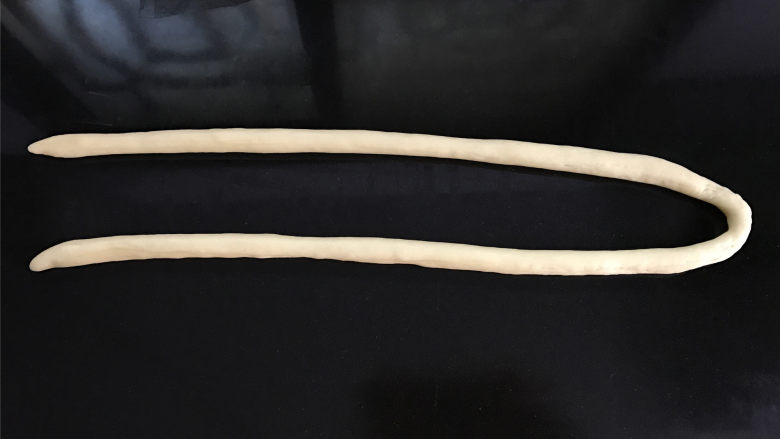 蛋奶麻花,取一个松驰好小剂子,慢慢搓长,搓的时候要从中间往两边搓,大约搓成80公分长的样子。