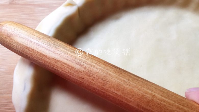 肉桂苹果派,取大的面团,用擀面杖擀成薄片后铺在派盘上,用手轻压派皮,使其能紧贴派盘,随后用擀面杖把多余的派皮切断