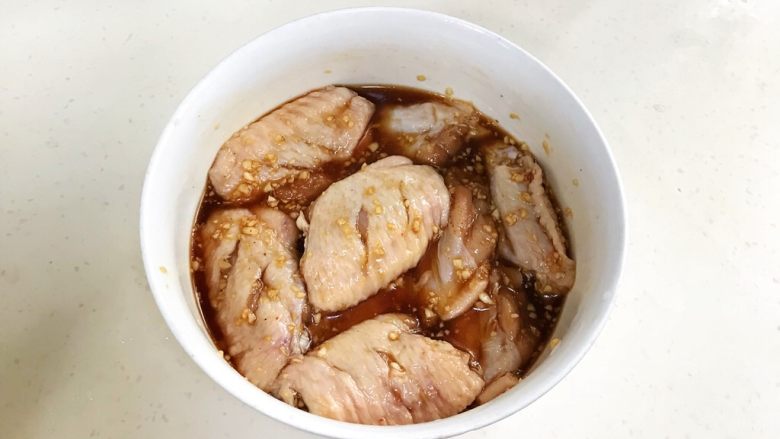 蜜汁鸡翅,把鸡翅里倒入混合好的酱料,搅拌均匀,盖上保鲜膜,放冰箱冷藏腌制一天。