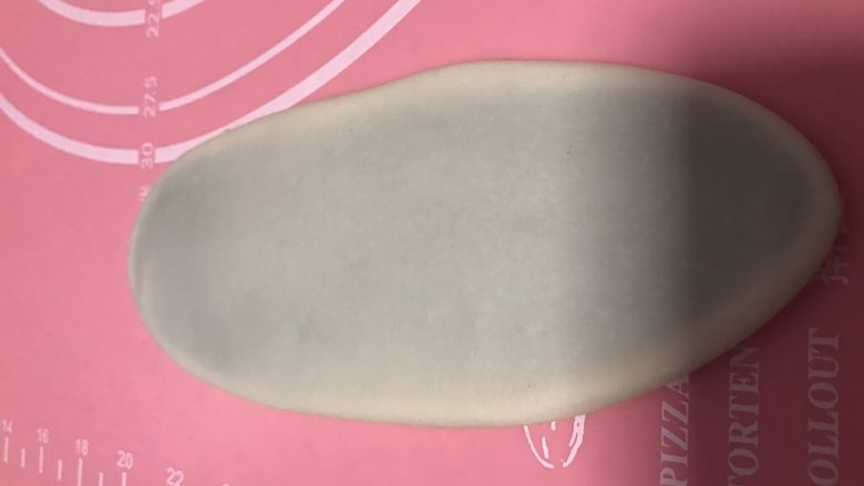 螺旋蛋黄酥,用手先稍微压扁,用擀面杖轻轻的擀成牛舌状,不要太用力,不然油皮容易破,擀大概18厘米长8厘米宽的样子,然后从上往下卷起来,盖上保鲜膜再松弛20分钟。松弛好后再次擀开卷起(手太油部分照片没拍)