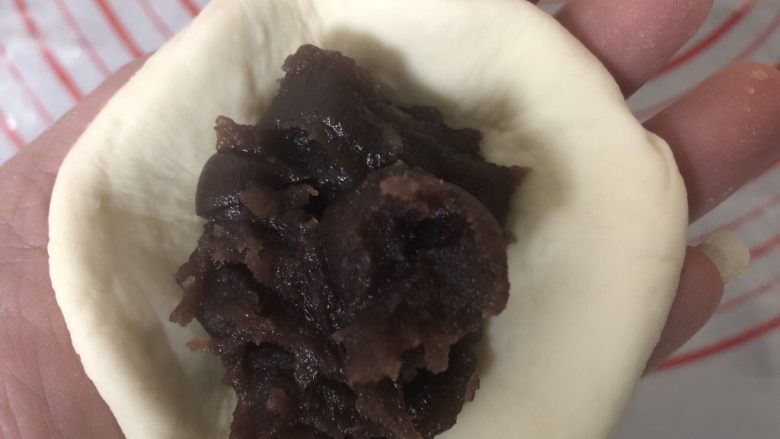 豆沙猪猪包,取一个小剂子擀开,包入适量豆沙。