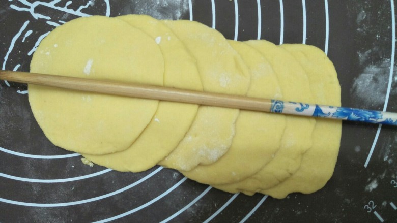 花开富贵馒头,将面团撠成大小约相同的面皮,将面皮如上图就样叠起来,用筷子在面皮中间压一道印痕。