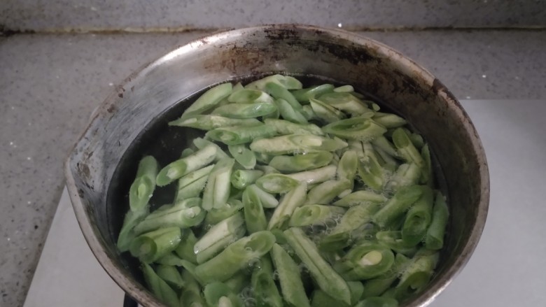豆角素卤面,小锅中放入适量水,水开后放入豆角焯水2分钟,再放入胡萝卜焯水1分钟。