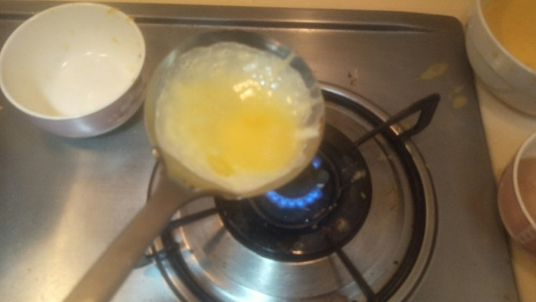 “金元宝”蛋饺,继续晃动。一定要涂满猪油,看到蛋皮边缘开始凝结了。