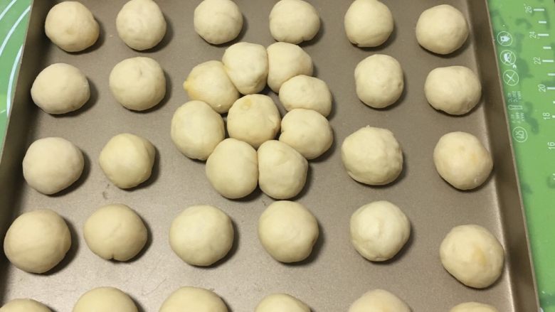 奶黄小面包,再一个个滚圆,放入金盘。