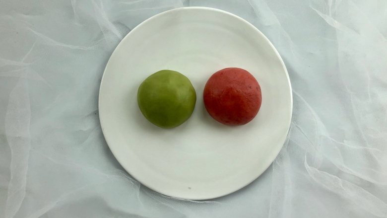 新年自制伴手礼—双色绣球酥,把(油酥)面团平均分成两份,分别揉进适量的草莓粉和麦青粉,揉至颜色均匀备用。