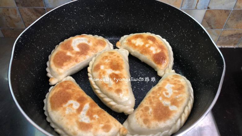 韭菜盒子,底部煎至金黄色就把韭菜盒子翻个面翻面继续煎,两面都煎至金黄色即可出锅
