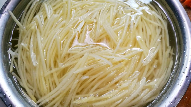 超爽口的凉拌土豆丝,土豆去皮切成丝泡水中10分钟,再重复浸泡清洗几次。