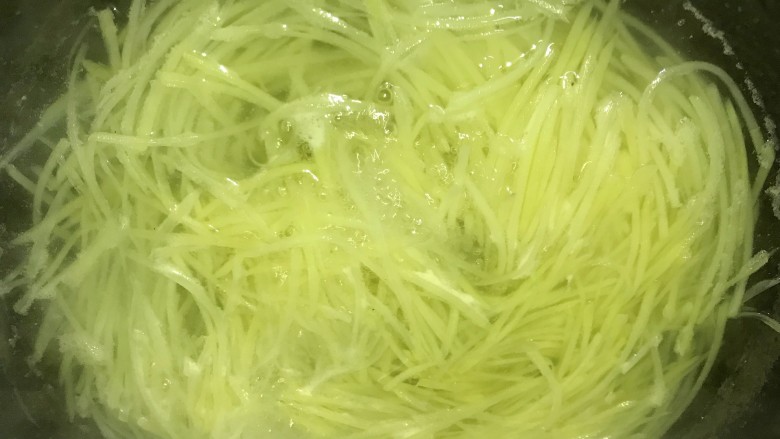 超爽口的凉拌土豆丝,锅内烧开水,放入土豆丝,煮至变色。捞起土豆丝沥干水分,放入凉开水中浸泡,几分钟后拿出沥干水分。