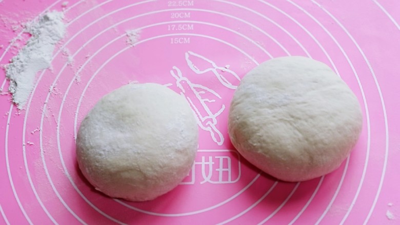 披萨新吃法~奥尔良鸡丁披萨,发酵好的面团取出,分成2份,盖上湿布揉圆醒发10分钟。