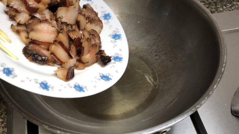 #猪年#舌尖上的家乡味➕腊肉蒜苗炒豆丝,热锅后转小火,放少许食用油,因为腊肉还会出油,放入腊肉小火煸炒到两面焦黄。