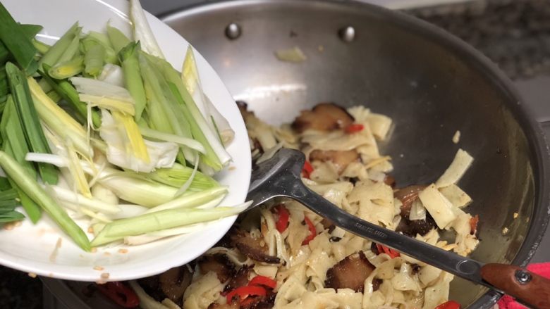 #猪年#舌尖上的家乡味➕腊肉蒜苗炒豆丝,炒到豆丝表面微焦,加入蒜白翻炒均匀