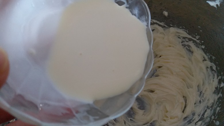 巧克力豆曲奇,把淡奶油分三次加入到黄油里,用电动打蛋器打发黄油。