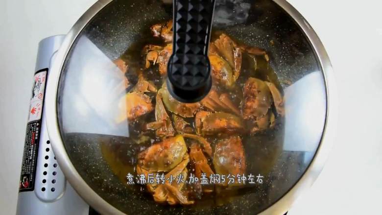 毛蟹年糕,倒入没过毛蟹一半的清水,加入少许白糖调味,继续炒匀,煮沸后转小火,加盖焖5分钟左右。
