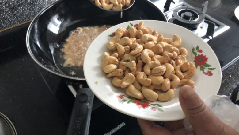 炸腰果,等所有的腰果都成金黄色以后捞出,控干油,倒入碗中就可以了!