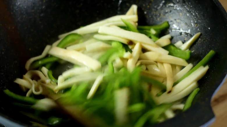 青椒炒杏鲍菇,多吃蔬菜身体好,况且还能吃出肉的口感,倒入青椒丝炒至断生。